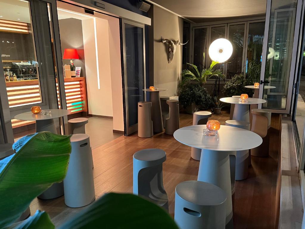 a restaurant with tables and stools in a room at Eco Hotel Cleofe in Caorle