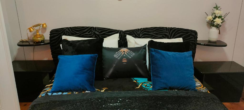 een bed met vier kussens in een kamer bij Grand Studios 54 in Faro