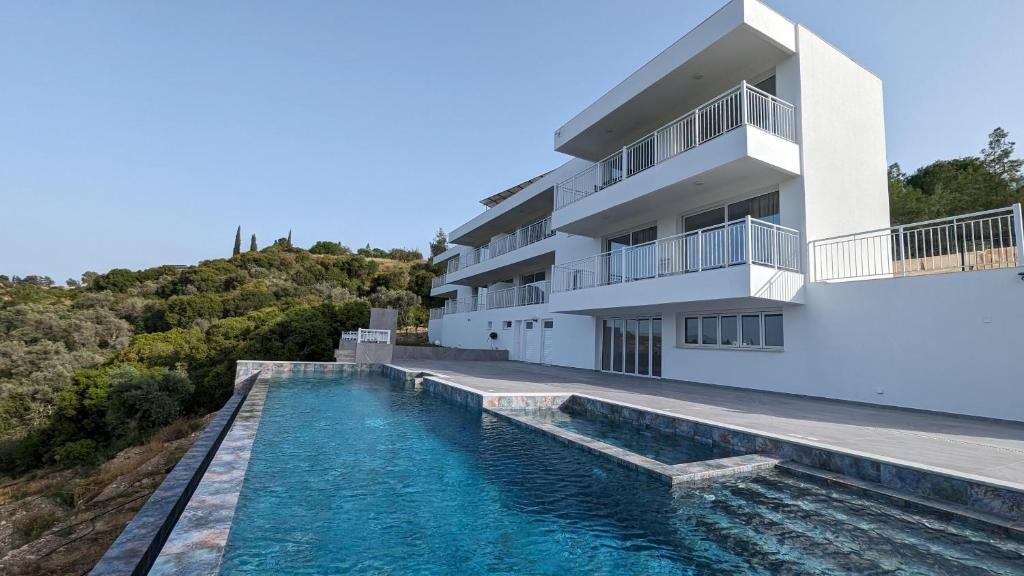 a house with a swimming pool next to a building at AKAMAS THRONE APARTMENTS in Neo Chorio