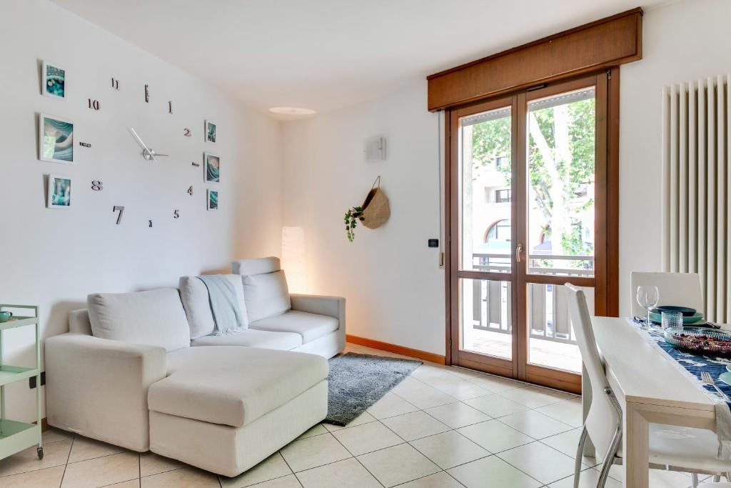 sala de estar con sofá blanco y mesa en Residenza Quadrifoglio, en Cesena