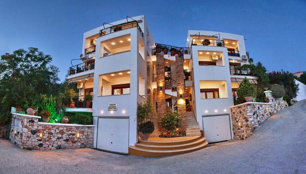 a large white building with stairs in front of it at Panorama Apartments in Plomari