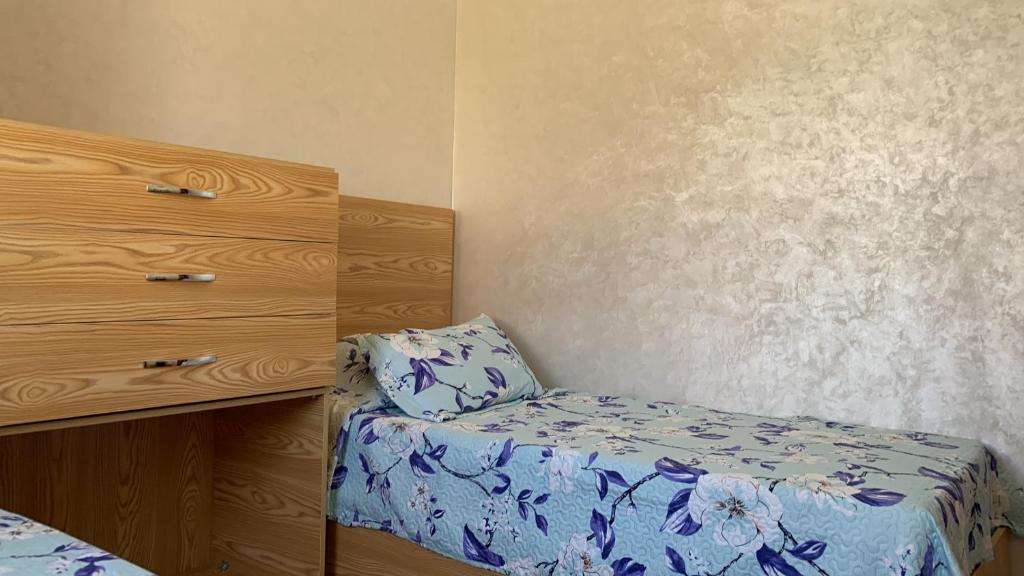 um pequeno quarto com uma cama e uma cómoda em Achakar em Tânger