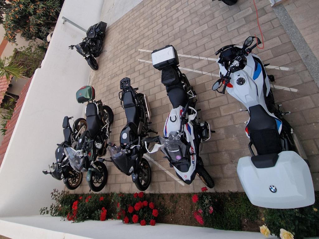 two motorcycles parked next to a brick wall at B&B EDEN OGLIASTRA in Tortolì