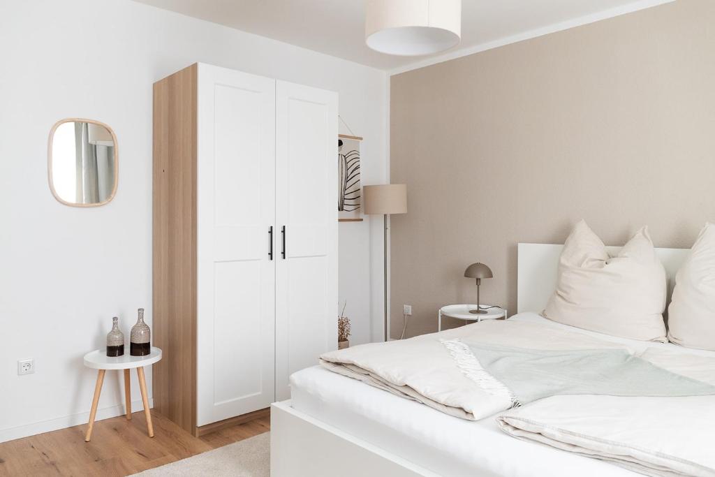 a bedroom with a white bed and a white cabinet at Soulplace Herten - warm & gemütlich in Herten