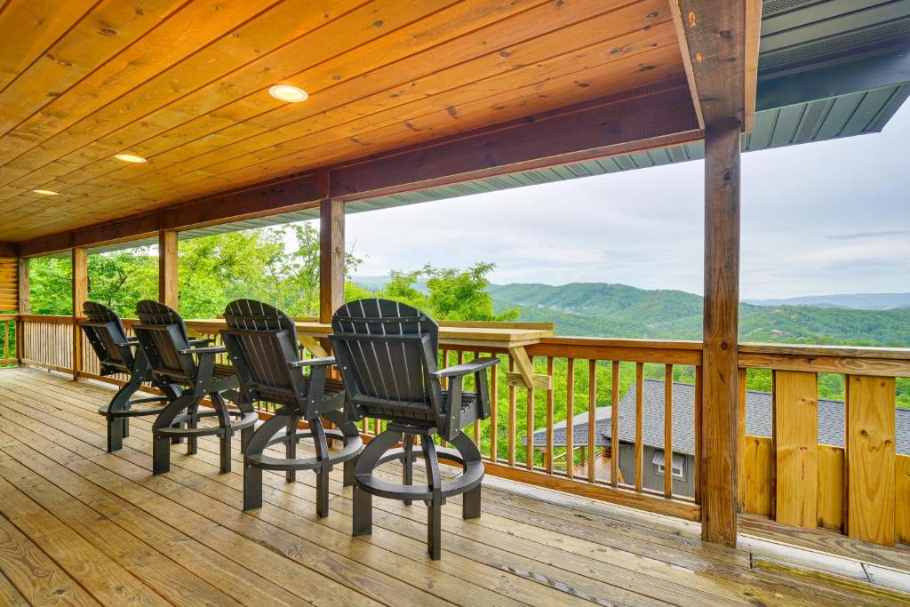 eine Veranda mit Stühlen und einem Tisch auf einer Terrasse in der Unterkunft Gatlinburg Cabin in the Clouds with Hot Tub and Views! in Gatlinburg