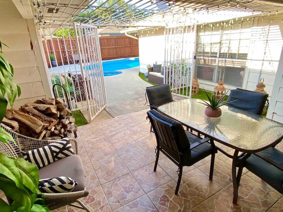 un patio con mesa, sillas y piscina en Vacation Home with Private Pool, en Dallas