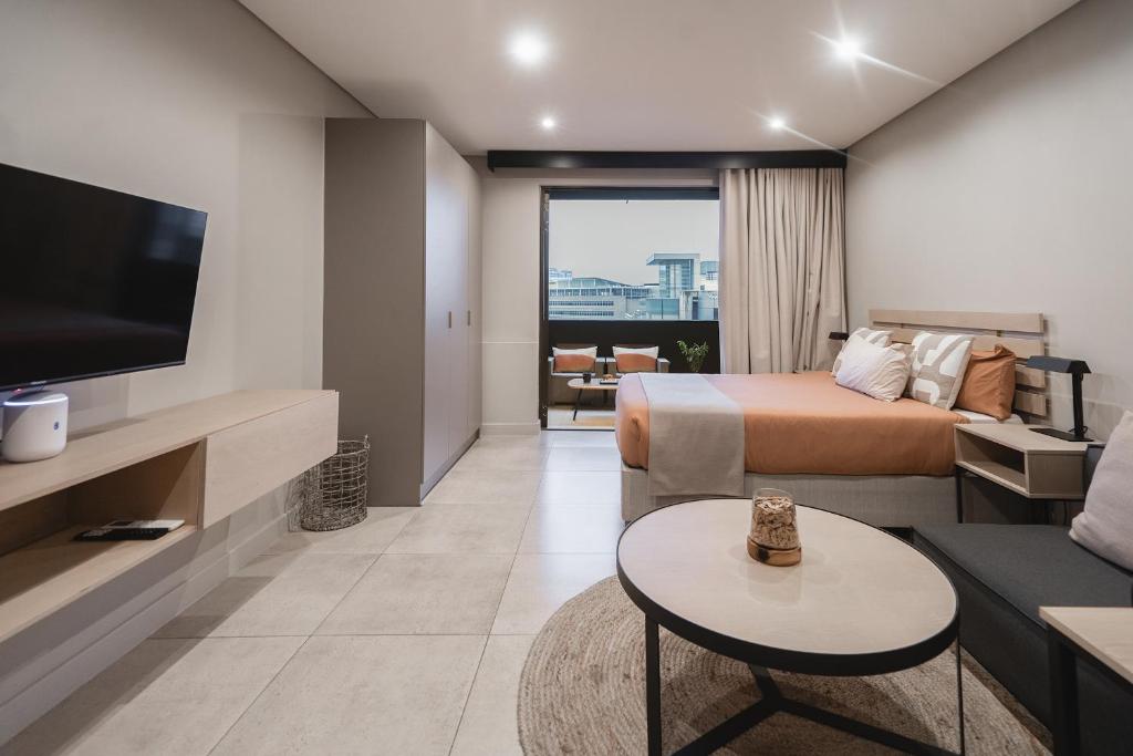 ein Hotelzimmer mit einem Bett und einem TV in der Unterkunft Top-Floor Urban Oasis located in the heart of Sandton City Center in Johannesburg