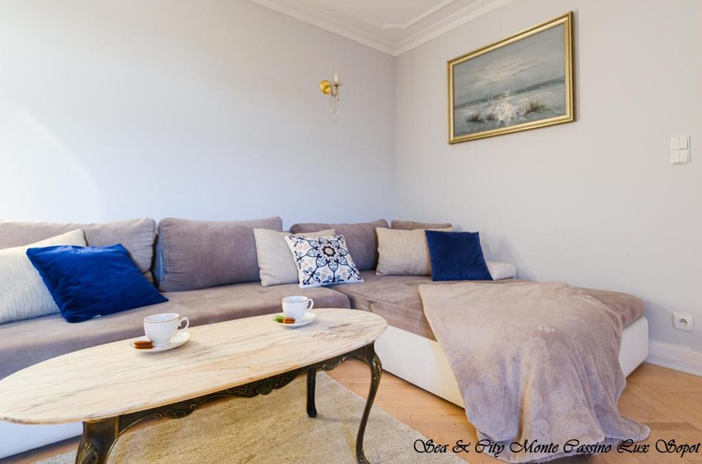 uma sala de estar com um sofá e uma mesa de centro em Sea & City 50 m Monte Casinno 100 m Beach Apartments Lux Sopot em Sopot