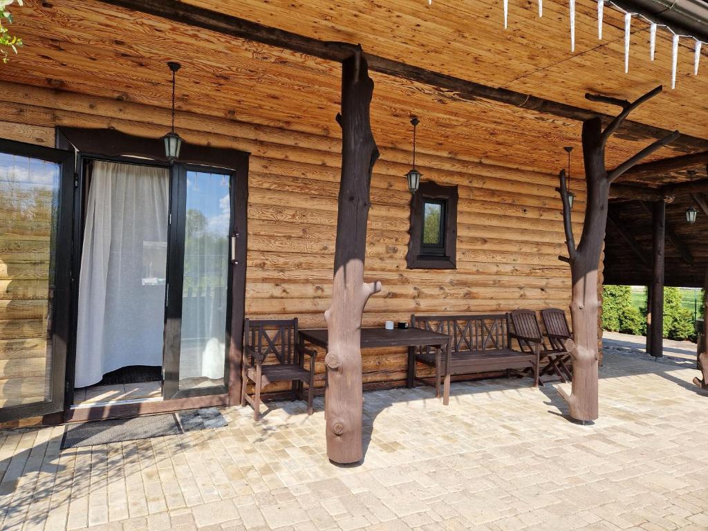 a log cabin with a table and chairs and windows at Brīvdienu māja pie Gaujas in Siguļi