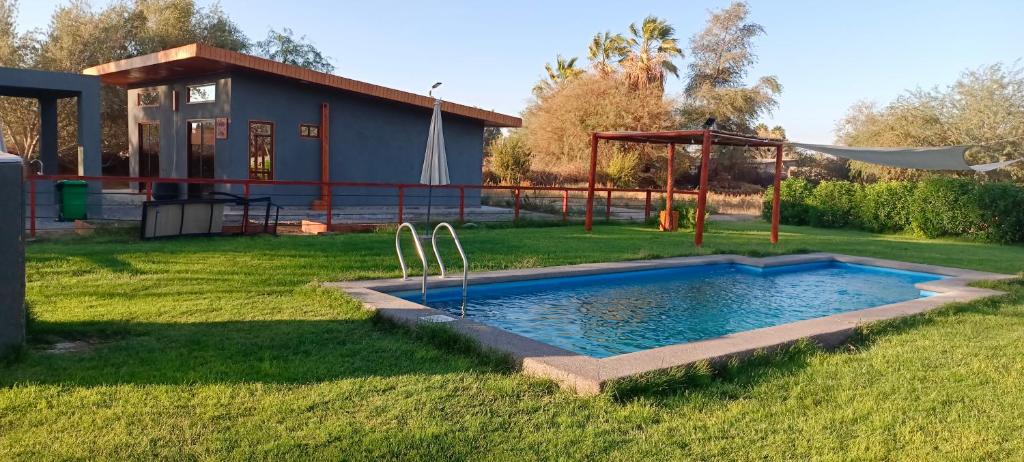 a swimming pool in a yard with a house at Cabañas Nonito in Pozo Almonte