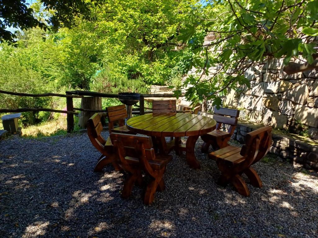 drewniany stół i krzesła na dziedzińcu w obiekcie Country House Cozzena w mieście Maslianico