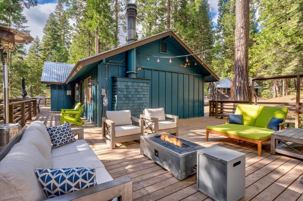 una casa azul con una hoguera en una cubierta en Starlight Cabin, en Oakhurst