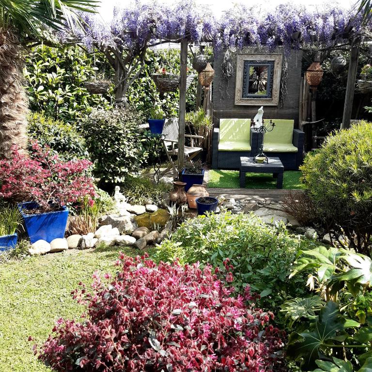 un jardín con pérgola con banco y flores en Chambre et jardin, en Bayona