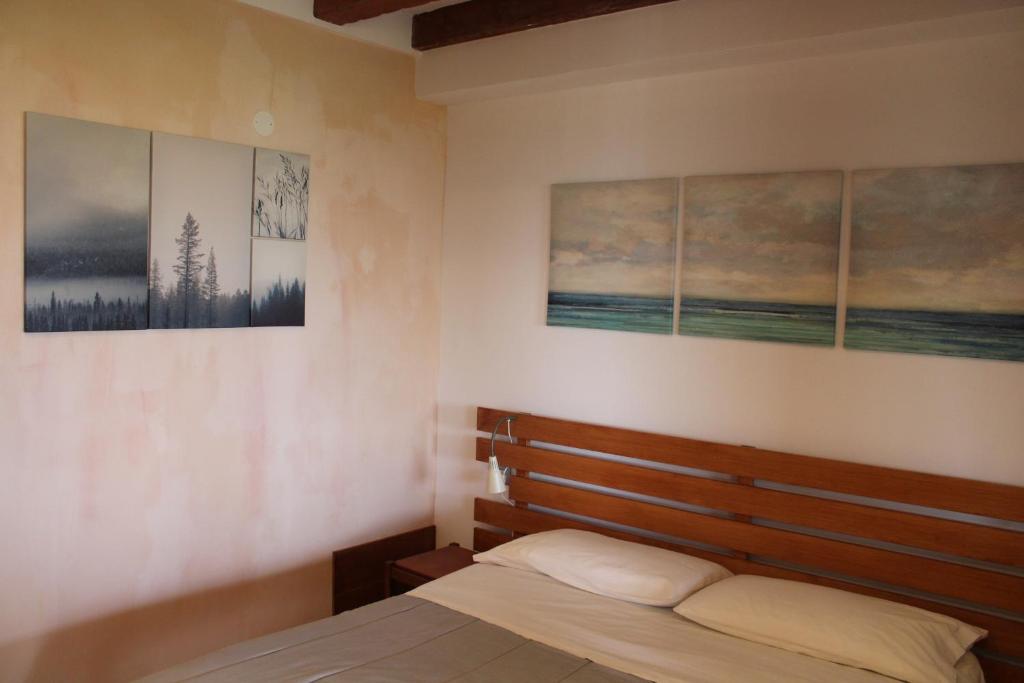 a bedroom with a bed and three pictures on the wall at Parma Country Room in Montechiarugolo