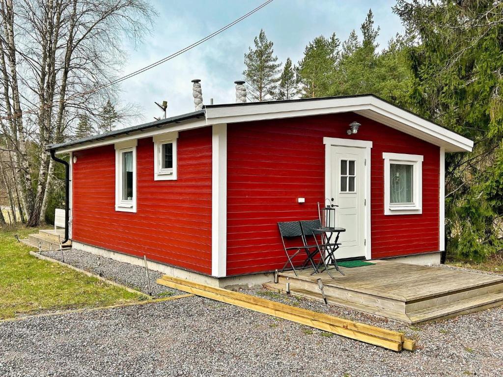 una casita roja con una silla en un porche en Holiday home UTTRAN, en Uttran