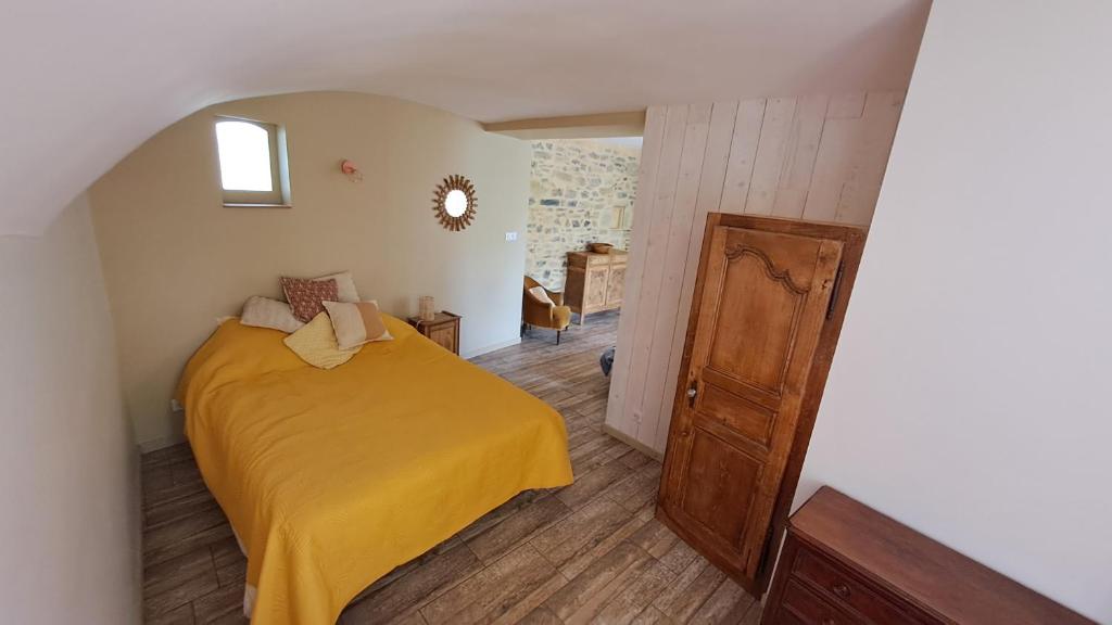 La bergerie d'Annie في بريفاس: غرفة نوم بسرير وبطانية صفراء
