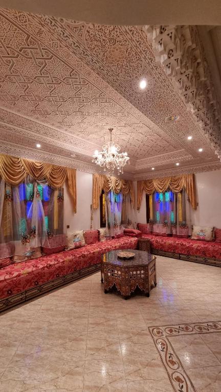 una grande stanza con divani rossi e lampadario a braccio di Villa with riad style a Fes