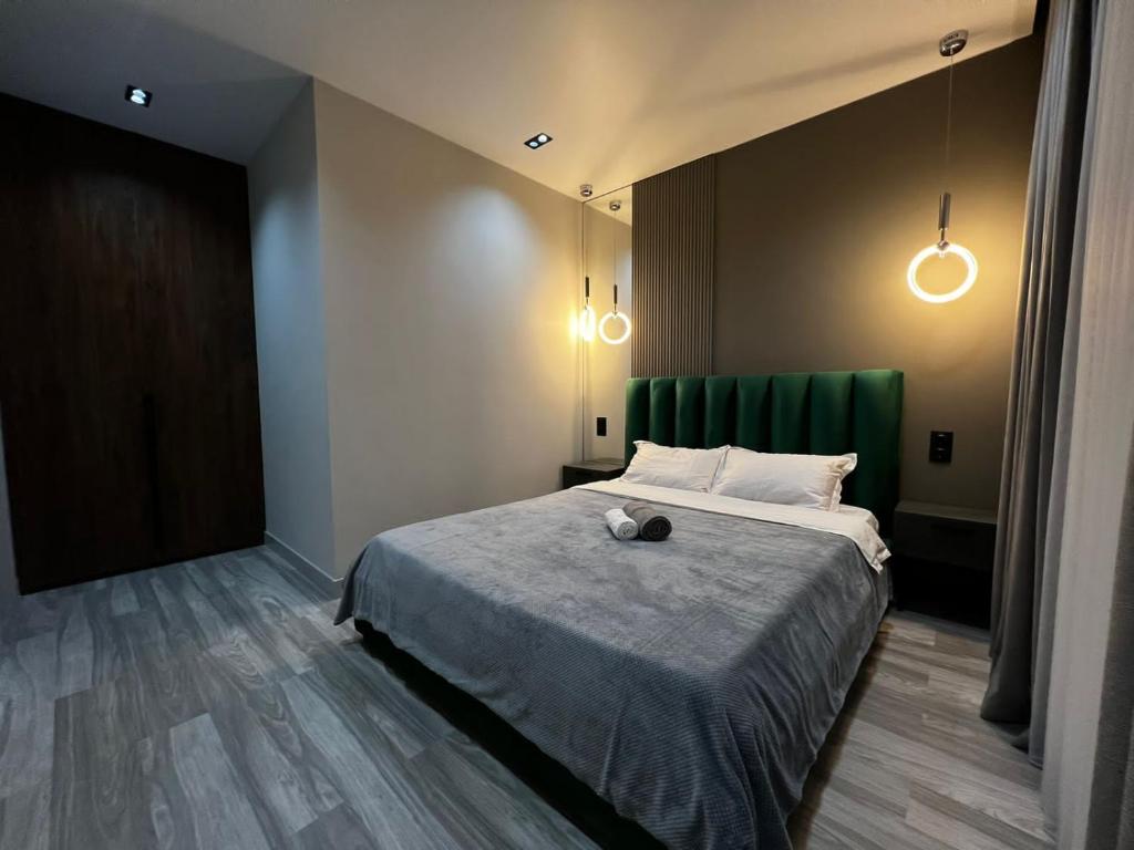 1 dormitorio con 1 cama con cortina verde y luces en Lux в ЖК K7-Family рядом аэропорт en Atyraū