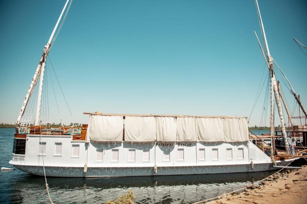a white boat is docked at a dock at Dahabiya Nile Cruise in Luxor
