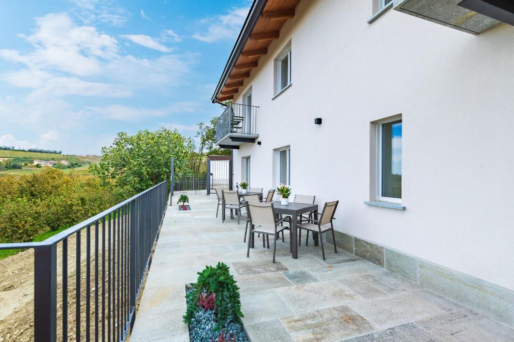 un patio con tavolo e sedie sul balcone. di Ca'd Felice - Villa nella natura con vista Langhe a Rodello