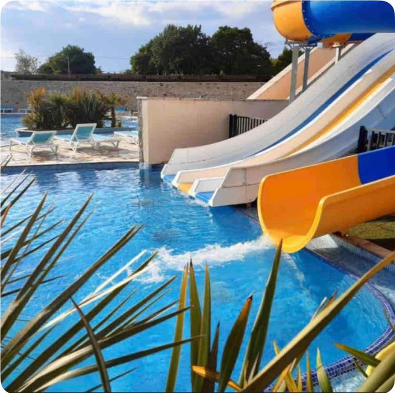 a pool with a water slide at a resort at Cosy Mobilhome in La Baule