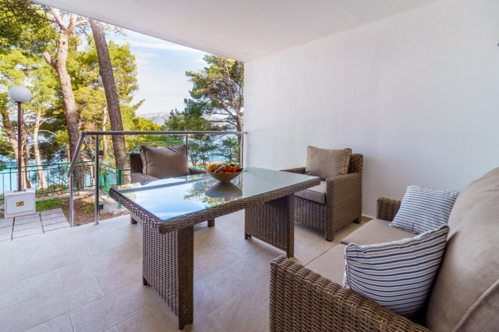 a patio with a table and chairs on a balcony at Lumbarda Driftwood in Lumbarda