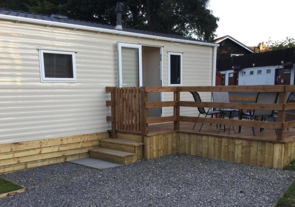 a mobile home with a porch and a deck at Poppy Lodge in Boat of Garten