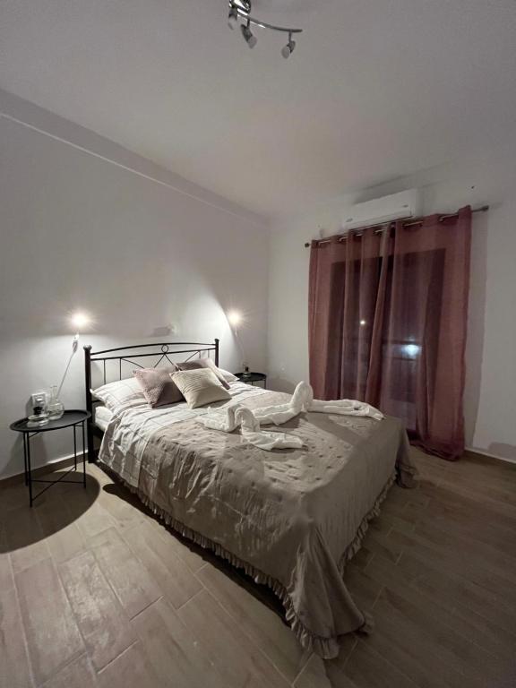 Un dormitorio con una cama grande y una ventana en Πεζούλα Μανη, en Yerolimin