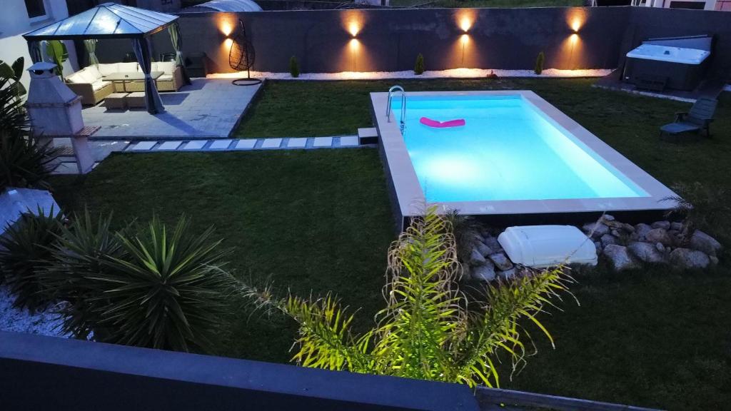 a backyard with a swimming pool at night at sand and sea in Póvoa de Varzim