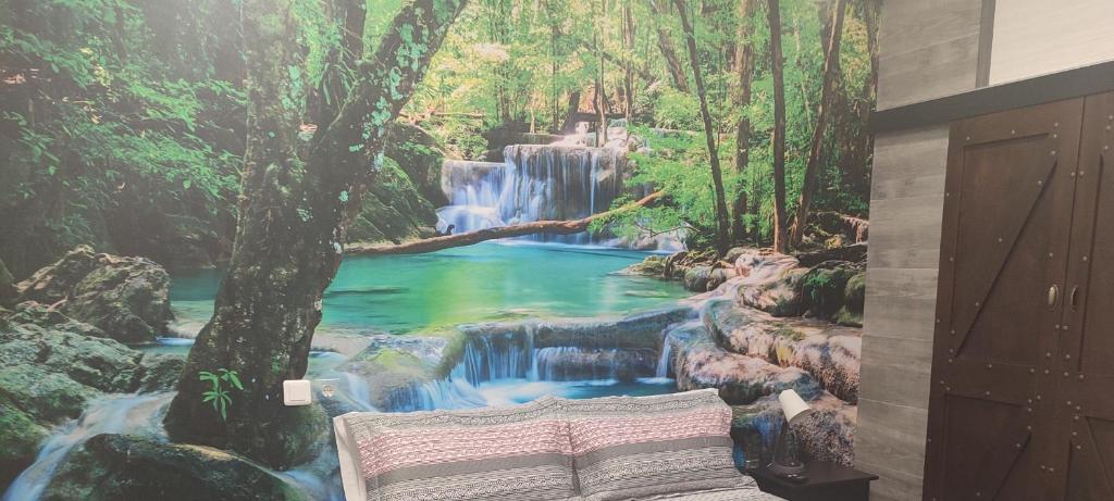 a bedroom with a waterfall mural on the wall at Hostal El Bosque Encantado Toledo in Toledo