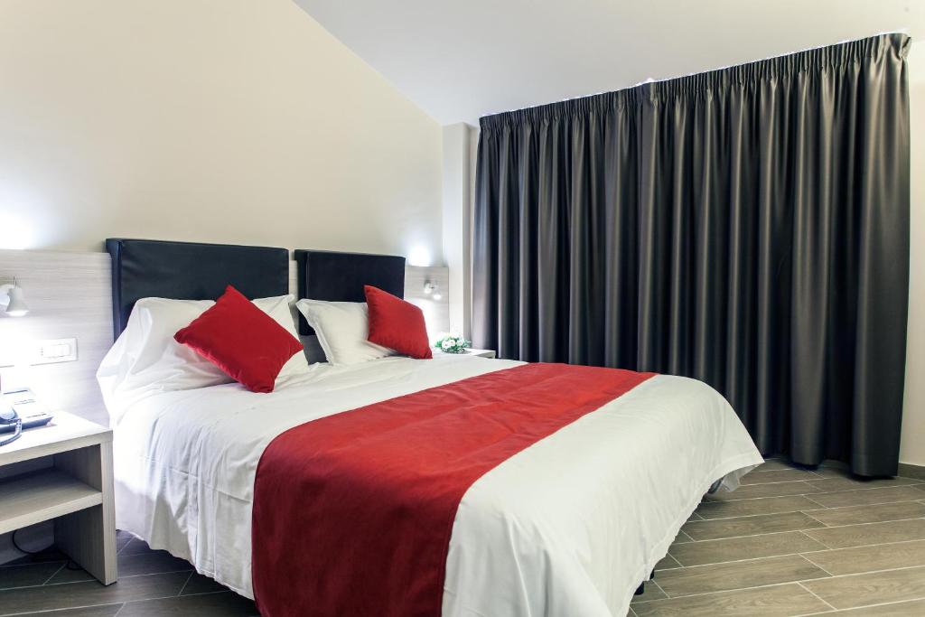 a bedroom with a large bed with red pillows at Hotel Los Angeles in Assisi