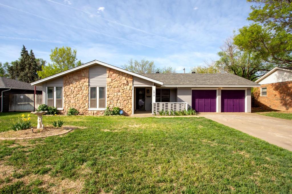 uma casa com uma garagem roxa num quintal em Pet-friendly 3br 2ba with huge, fenced yard! em Amarillo