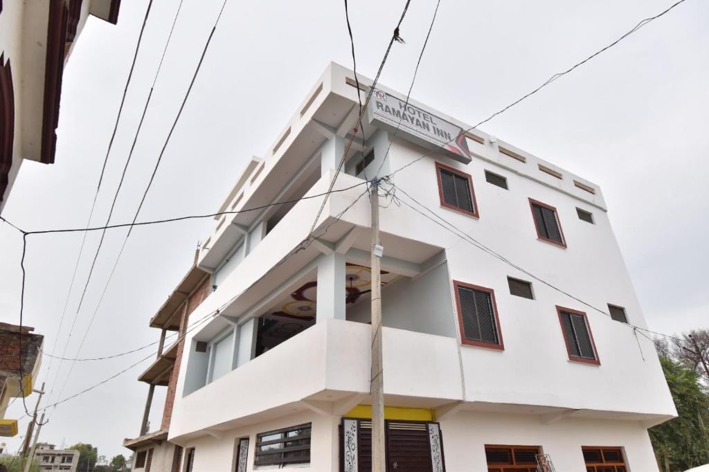 un edificio blanco con un cartel. en HOTEL RAMAYAN INN FREE PICKUP FROM AYODHYA DHAM RAILWAY STATION, en Ayodhya
