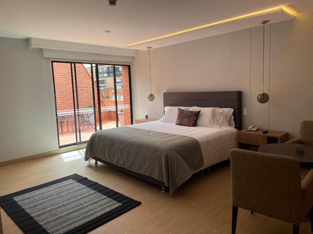 a bedroom with a bed and a large window at Hotel Parque 97 Suites in Bogotá