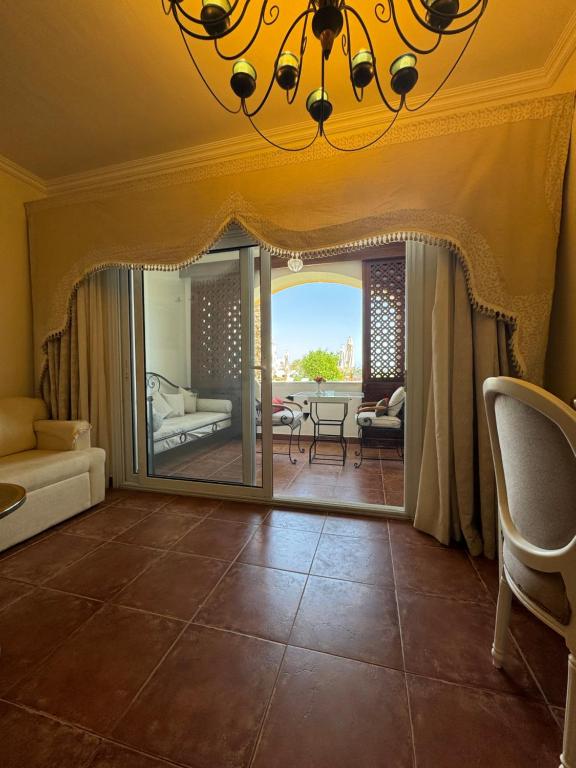 a living room with a chandelier and a large glass door at Sharm Prestige Room 52 - Luxury sea view at coral bay in Sharm El Sheikh