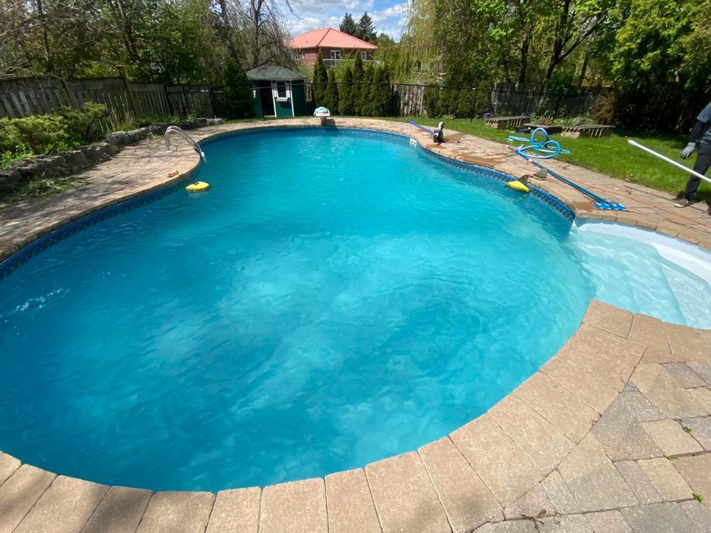 a large pool with blue water in a yard at 旺市中心带泳池的奢华房间 in Vaughan