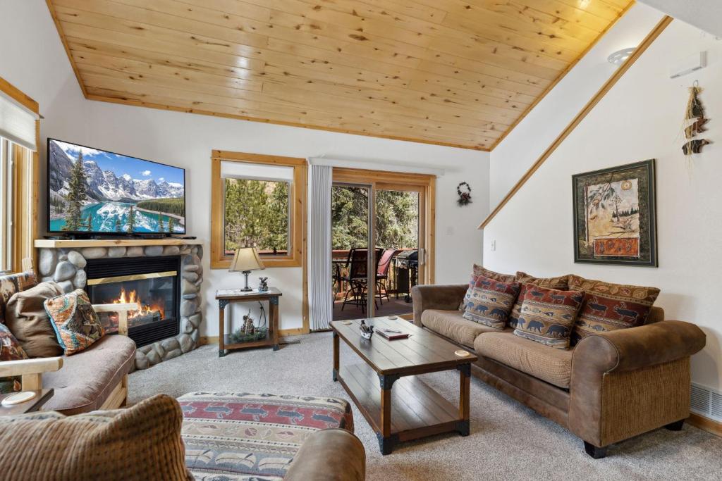 a living room with couches and a fireplace at Bugle Pointe A06 by Estes Park Condos in Estes Park