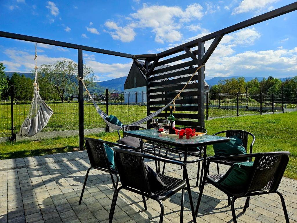 d'une terrasse avec une table, des chaises et un hamac. dans l'établissement Zacisze w Karkonoszach, à Karpacz