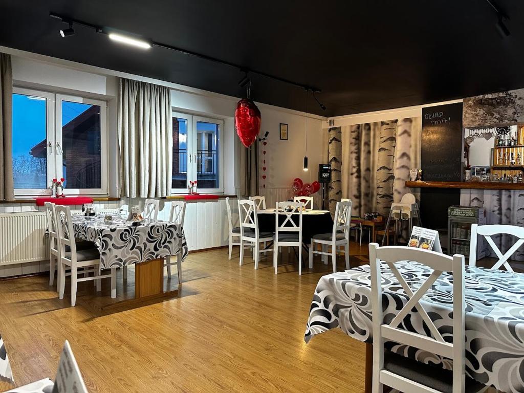 een kamer met tafels en stoelen en een eetkamer bij La Familia TYBURA in Uniejow