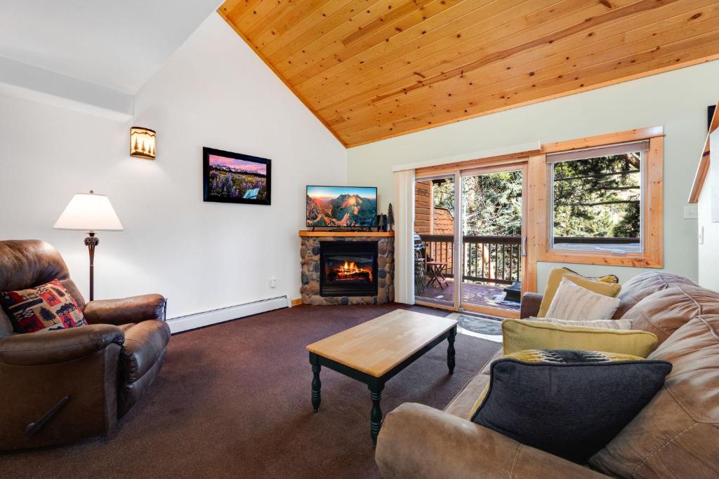 sala de estar con sofá, sillas y chimenea en Bugle Pointe B15 by Estes Park Condos, en Estes Park