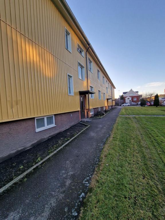 budynek z żółtą ścianą obok pola w obiekcie Lugn och skön lägenhet centralt. w Göteborgu