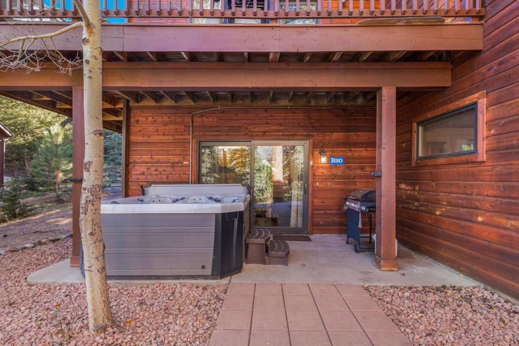 a deck with a hot tub on the side of a house at Bugle Pointe B20 by Estes Park Condos in Estes Park