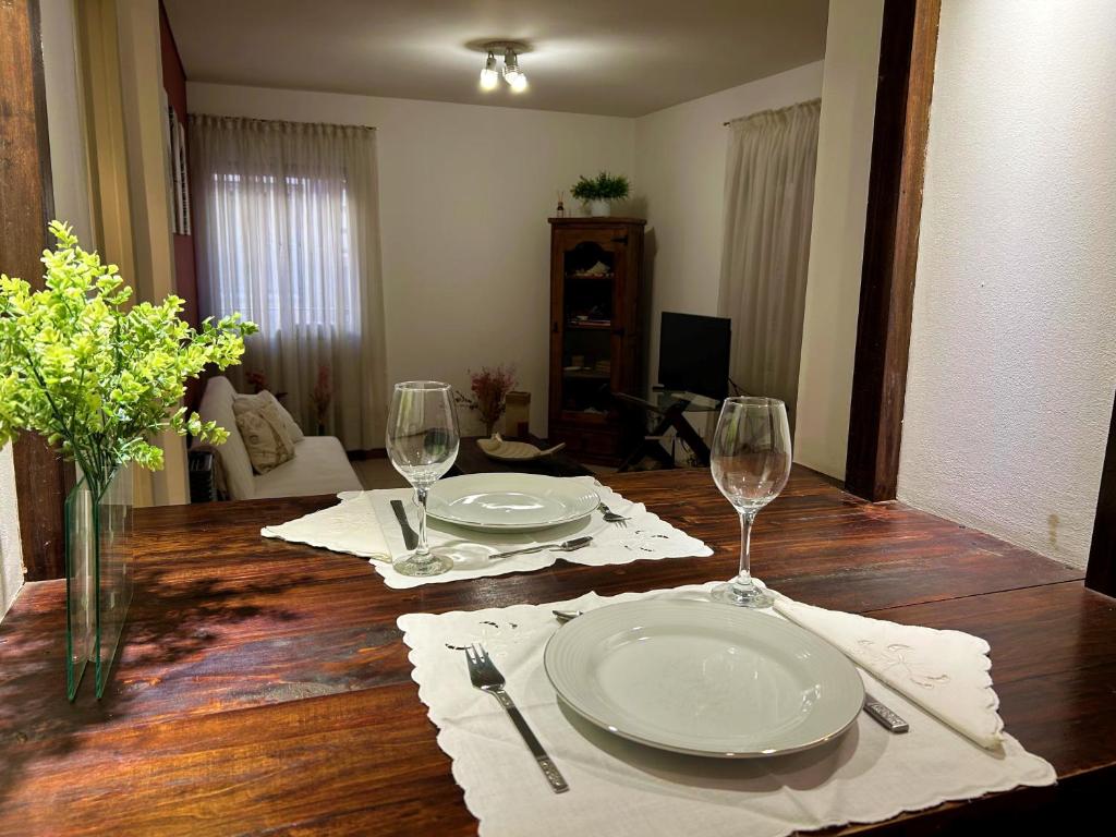 una mesa de comedor con 2 platos y copas de vino en Mendoza C&D en Godoy Cruz