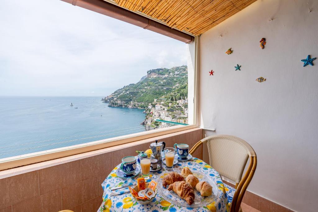 una mesa con vistas al océano desde una ventana en Casa Maria Vittoria en Minori