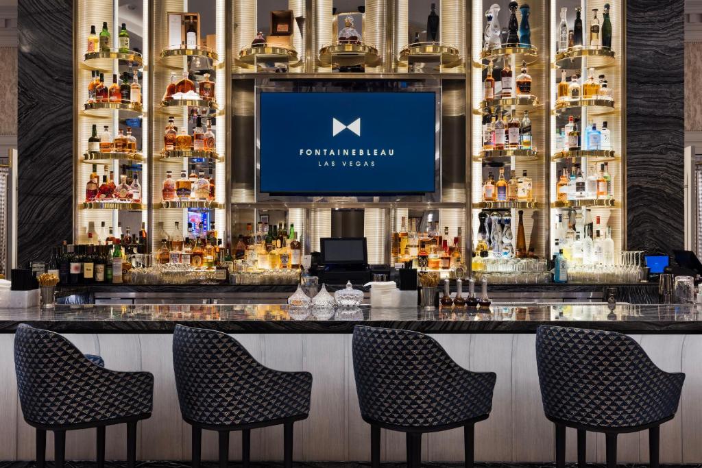 eine Bar in einem Restaurant mit Stühlen und einem TV in der Unterkunft Fontainebleau Las Vegas in Las Vegas