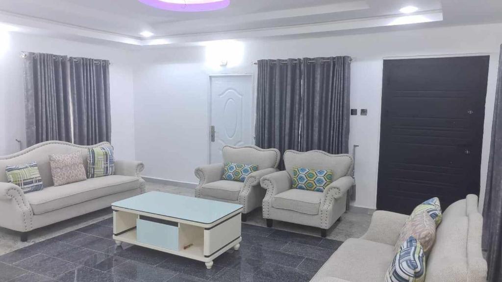 Sala de estar con sofás y mesa de centro en IBADAN LUXURY APARTMENT en Moniya