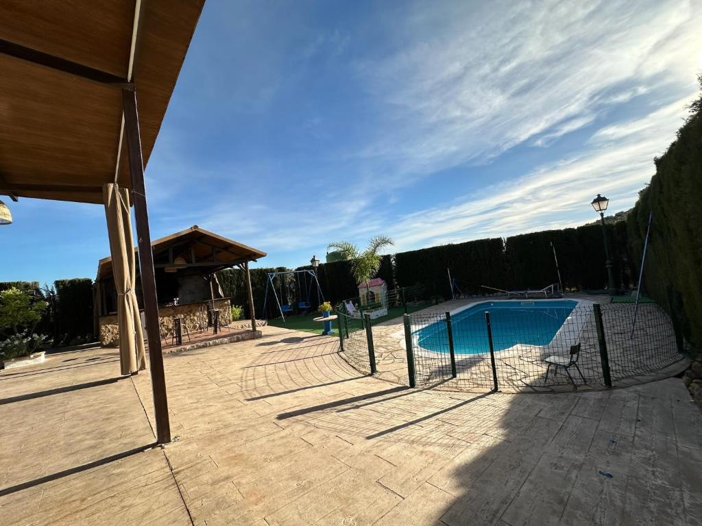 a swimming pool with a fence around it at Dehesa Elías in Lucena