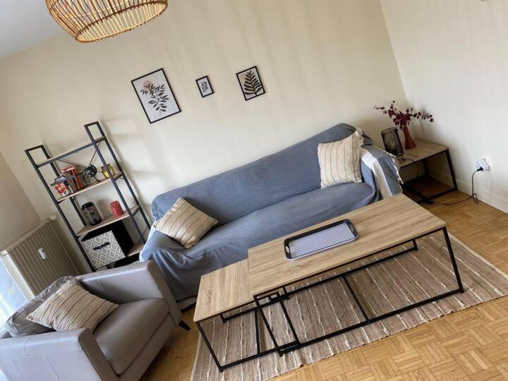 un salon avec un canapé bleu et une table basse dans l'établissement Bon séjour - Appartement 3 chambres, à Chalon-sur-Saône