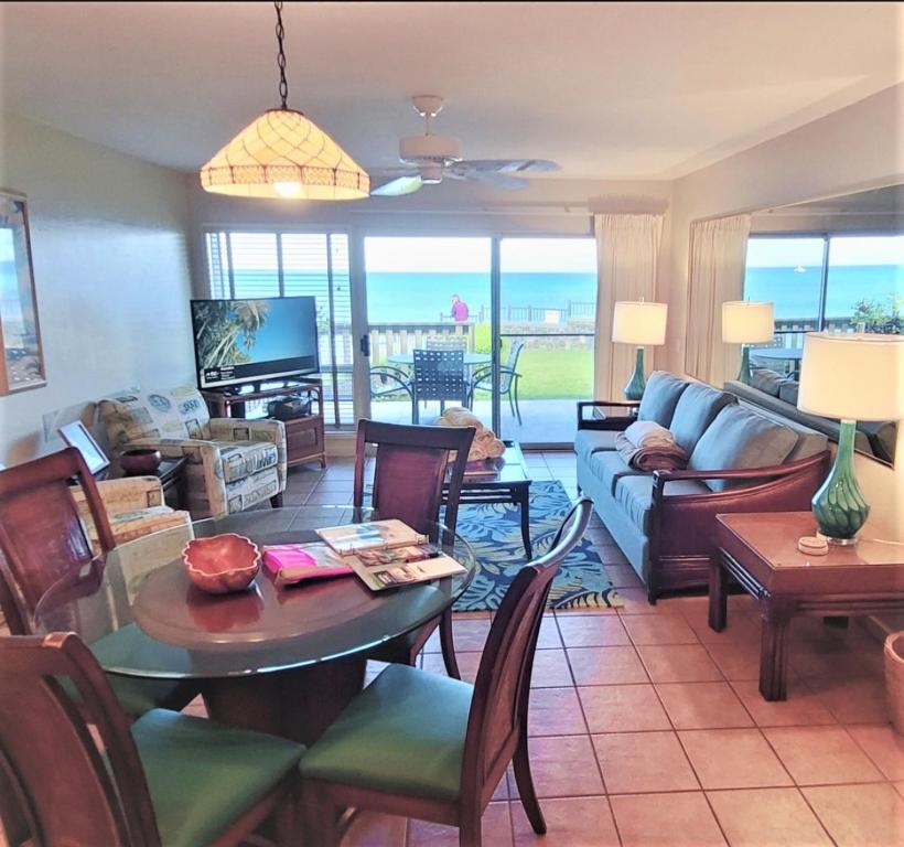 een woonkamer met een bank en een tafel bij Oceanfront & Sunsets! ks a5- Sullivan in Kahana