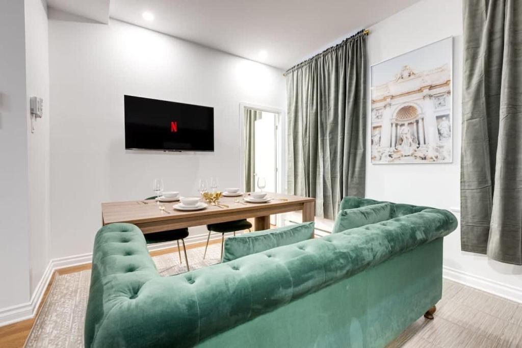 uma sala de estar com um sofá verde e uma mesa em M11 Beautiful Cozy 2BR wAC Perfect Location em Montreal